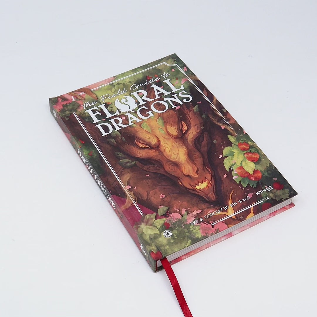 A book called "The Field Guide to Floral Dragons" being opened and flipped through.